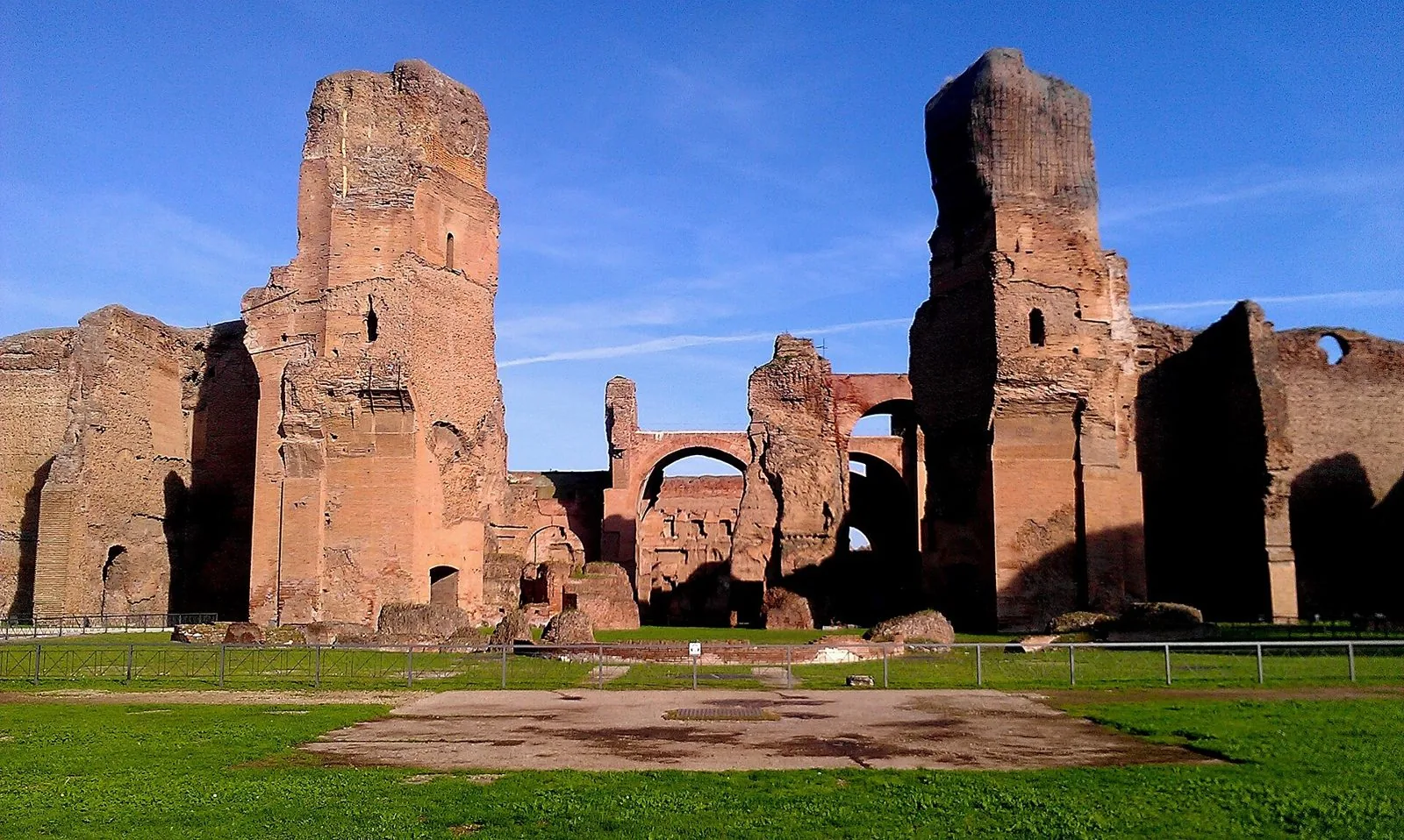 Le alte murature in laterizio del calidarium delle Terme di Caracalla sotto un cielo azzurro