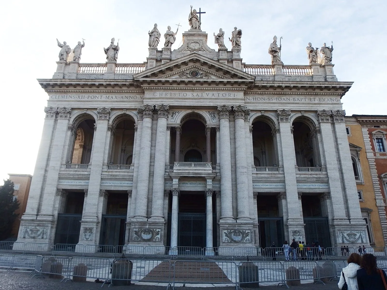 La facciata settecentesca della Basilica di San Giovanni in Laterano con colonne giganti, loggia centrale e statue di santi sulla balaustra